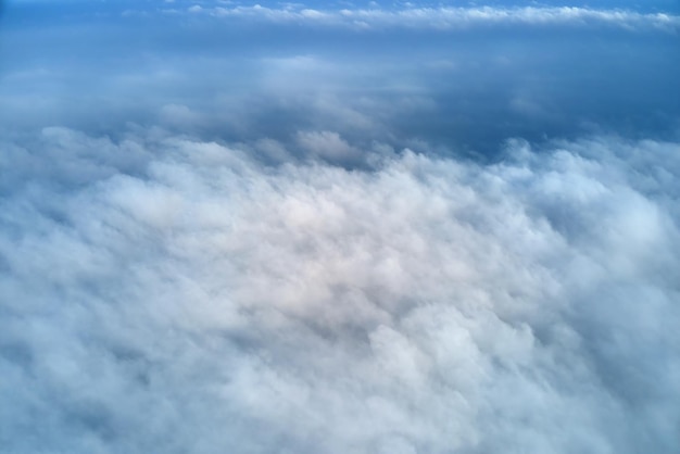 Luftaufnahme aus großer Höhe der Erde, bedeckt mit geschwollenen Regenwolken, die sich vor dem Regensturm bilden.