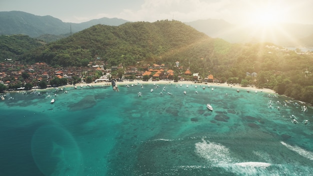 Luftaufnahme Crystal Ocean Harbour Bay weißer Strand und grüne Waldberge bei Sonnenuntergang weiches Licht