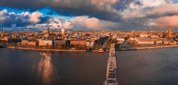 Luftaufnahme der Altstadt von Riga in der Abenddämmerung mit stürmischen Wolken und leichtem Regen im Sonnenlicht