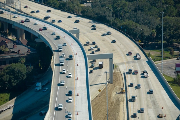 Luftaufnahme der amerikanischen Autobahnkreuzung mit schnell fahrenden Autos und Lastwagen USA-Transportinfrastrukturkonzept