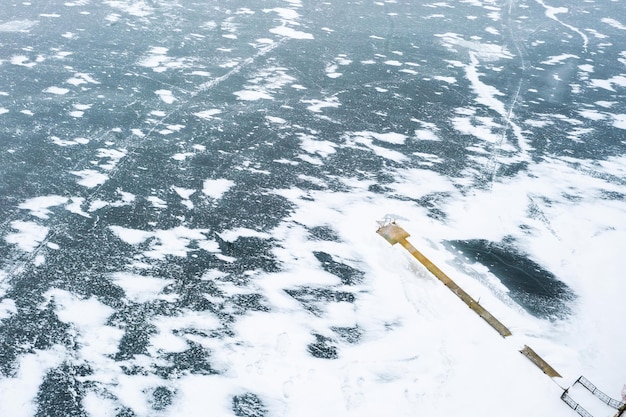 Luftaufnahme der Anlegestelle am schneebedeckten See Winterlandschaft gefrorener See und mit Schnee bedeckt