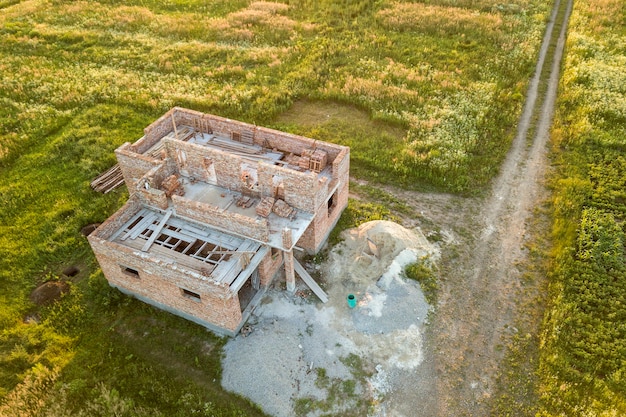 Luftaufnahme der Baustelle für zukünftiges Haus, Ziegelkellerboden und Ziegelstapel für den Bau.