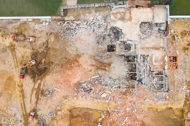 Luftaufnahme der Baustelle mit zerstörtem Industriegebäude und Baggern.