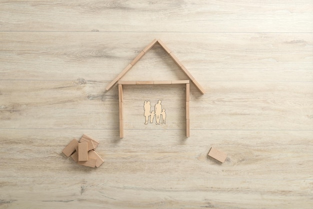 Luftaufnahme der Form eines Wohnhauses aus Bauholzklötzen für eine Familie mit drei Kindern