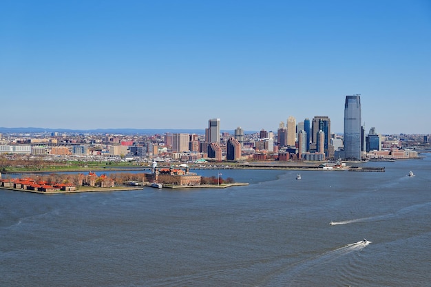Luftaufnahme der Governors Island im Hafen von New York City an einem klaren Frühlingstag mit Brooklyn Vision im Hintergrund