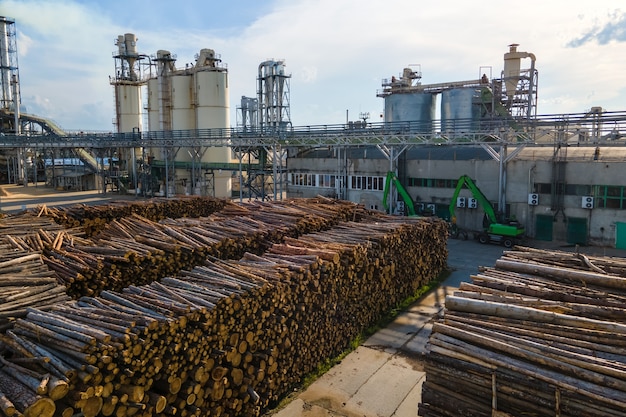 Luftaufnahme der Holzverarbeitungsfabrik mit Holzstapeln im Werksfertigungshof.