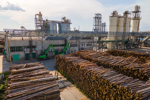 Luftaufnahme der Holzverarbeitungsfabrik mit Holzstapeln im Werksfertigungshof.