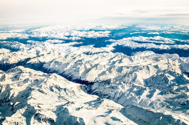 Luftaufnahme der italienischen Alpen mit Schnee und nebligem Horizont Reisekonzept und Winterurlaub auf weißen schneebedeckten Bergen Ausflug zu exklusiven Luxuszielen
