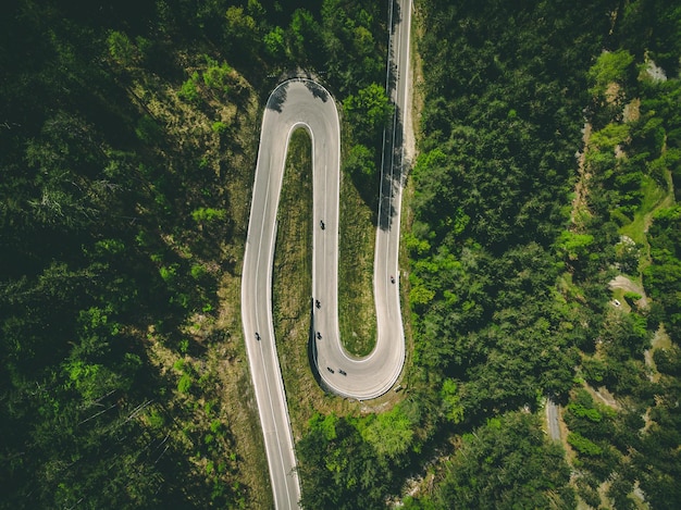 Luftaufnahme der kurvenreichen Landstraße mit Autos und Motorrädern in Italien