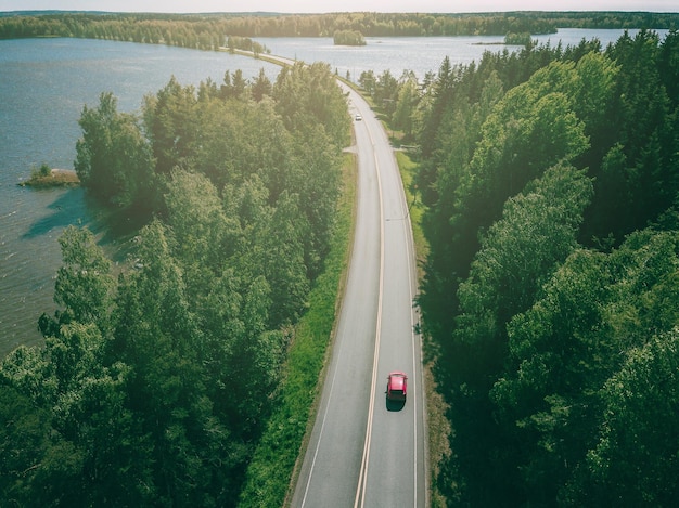 Luftaufnahme der landstraße durch grüne wälder und blaue seen in finnland