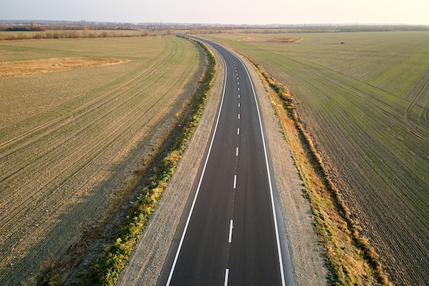 Luftaufnahme der leeren Intercity-Straße bei Sonnenuntergang. Draufsicht von der Drohne der Autobahn am Abend.