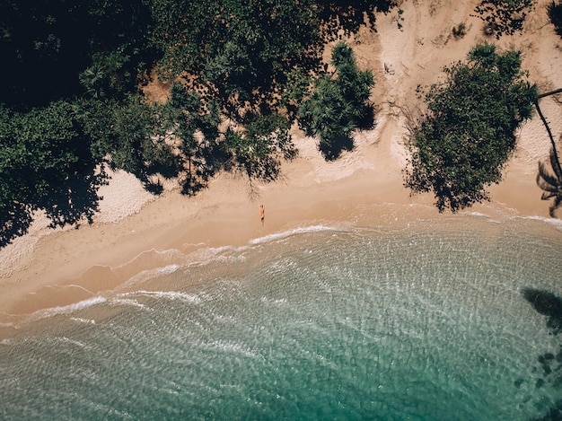 Luftaufnahme der liegenden Frau am Strand. Junge Frau auf dem Meer. Phuket. Thailand. Ansicht von oben. Meerblick mit Mädchen an der Küste, blauem Wasser und Wellen. Reisen