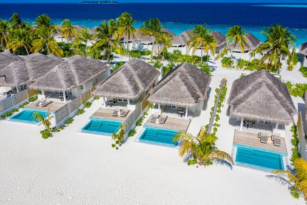 Luftaufnahme der Malediven-Insel, Luxus-Wasservillen-Resort und Holzsteg. Schöner Himmel und Ozean