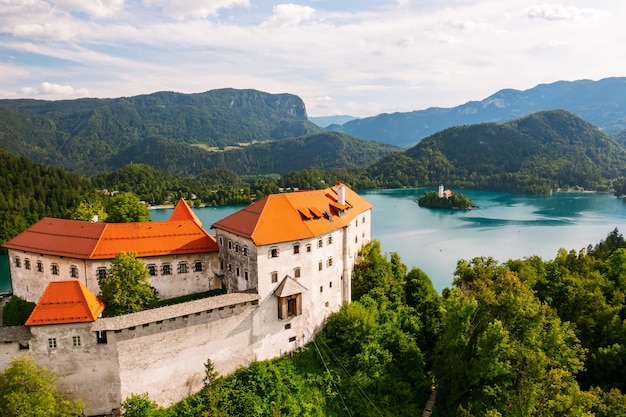 Luftaufnahme der mittelalterlichen Burg von Bled auf der Klippe des Berges unter dem mit Türkis gebluteten See