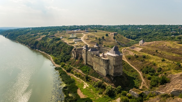 Luftaufnahme der mittelalterlichen Burg von Khotyn auf dem grünen Hügel über dem Fluss.