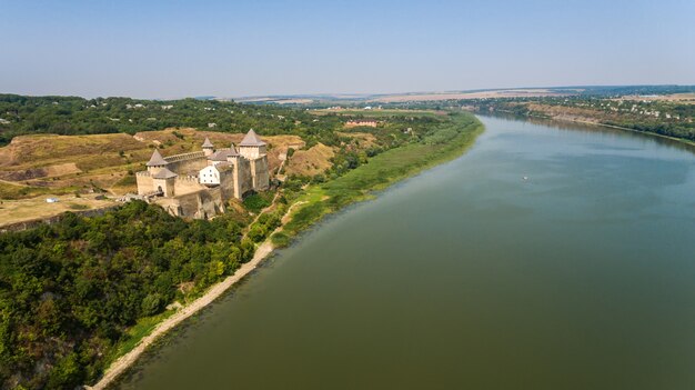 Luftaufnahme der mittelalterlichen Burg von Khotyn auf dem grünen Hügel über dem Fluss.