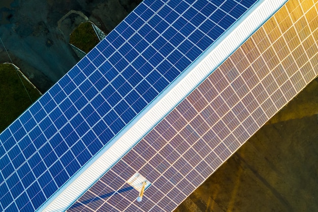 Luftaufnahme der Oberfläche von blauen Photovoltaik-Solarmodulen, die auf dem Dach des Gebäudes montiert sind, um sauberen ökologischen Strom zu erzeugen. Produktion eines erneuerbaren Energiekonzepts.