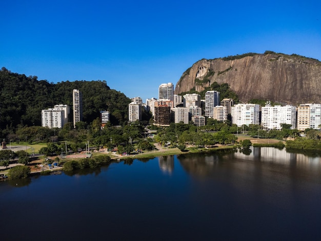 Luftaufnahme der Rodrigo de Freitas Lagune Südzone von Rio de Janeiro Brasilien Im Hintergrund die Strände von Ipanema und Leblon Sonniger Tag Autos, die auf der Avenida Epitacio Pessoa Drohnenfoto fahren