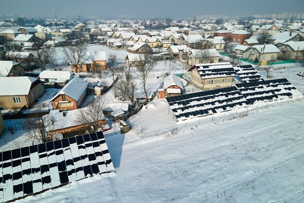 Luftaufnahme der Schneeschmelze von überdachten Photovoltaikmodulen, die auf dem Dach des Hauses installiert sind, um saubere elektrische Energie zu erzeugen Geringe Effektivität von erneuerbarem Strom im Winter in der Nordregion