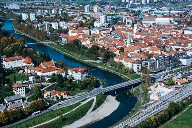 Luftaufnahme der Stadt Celje in Slowenien. Rote Dächer, Fluss und die Brücke. Reisehintergrund im Freien.
