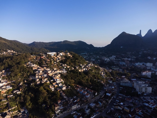 Luftaufnahme der Stadt Teresopolis Berge und Hügel mit blauem Himmel und vielen Häusern in der Bergregion von Rio de Janeiro Brasilien Drohnenfoto Araras Teresopolis Sonniger Tag Sonnenuntergang