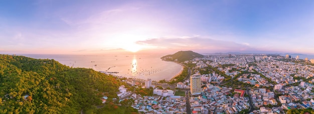 Luftaufnahme der Stadt Vung Tau mit wunderschönem Sonnenuntergang und so vielen Booten Panoramablick auf die Küste von Vung Tau von oben mit Wellen, Küstenstraßen, Kokospalmen und dem Berg Tao Phung in Vietnam