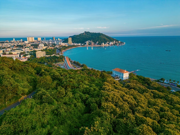 Luftaufnahme der Stadt Vung Tau mit wunderschönem Sonnenuntergang und so vielen Booten und Seilbahn Panoramablick auf die Küste von Vung Tau von oben mit Wellen Küstenstraßen Kokospalmen und dem Berg Tao Phung in Vietnam