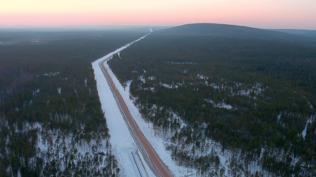 Luftaufnahme der Straße im Wald im Winter