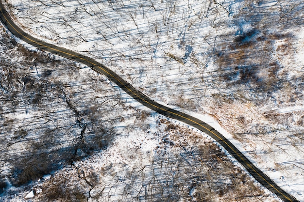 Luftaufnahme der Straße mit verschneitem Wald