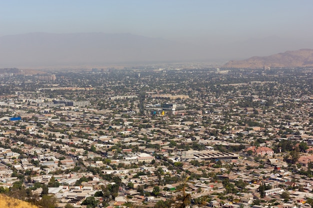 Luftaufnahme der überbevölkerten Stadt Santiago mit dichtem Smog auf den Anden im Hintergrund
