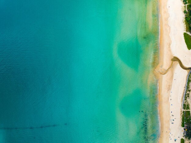 Luftaufnahme der Wellen des Meeres Weiße Schaumwellen auf dem StrandsandOberster Blick auf die Meeresspiegel Natur Meer Strand Sand Hintergrund.