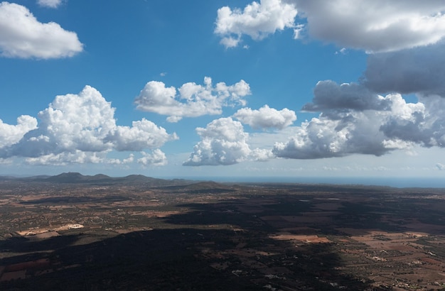 Luftaufnahme der Wolken, die Schatten über das Land werfen, mit dem Mittelmeer im Rücken