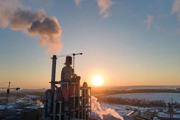 Luftaufnahme der Zementfabrik mit hoher Betonwerksstruktur und Turmkran im industriellen Produktionsbereich am Abend Herstellung und globales Industriekonzept