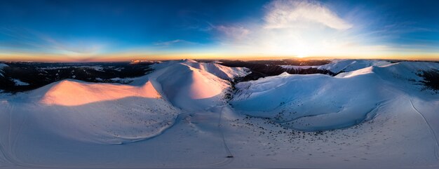 Luftaufnahme des atemberaubenden Winterpanoramas der schneebedeckten Hänge und Hügel