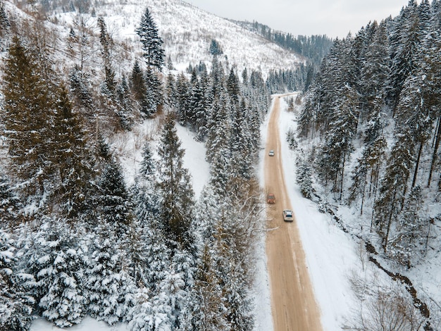 Luftaufnahme des Autos auf verschneiter Straße in der Wintersaison der Berge