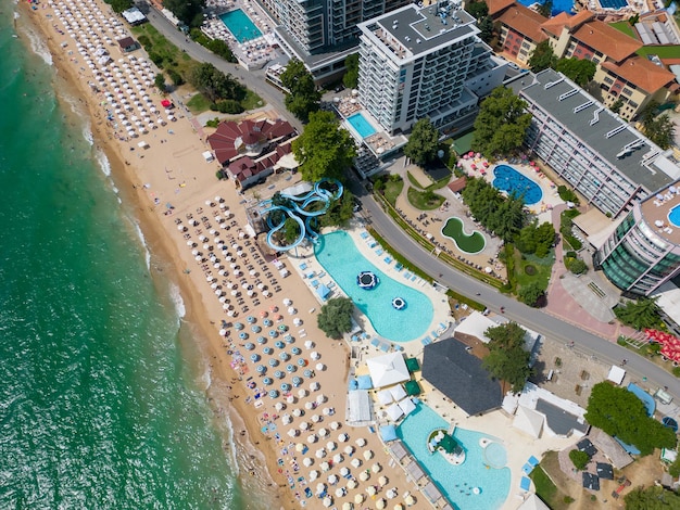 Luftaufnahme des bulgarischen Ferienortes Goldstrand während der Sommersaison mit einer Reihe von Hotelpools und Menschenmassen, die das Meer genießen