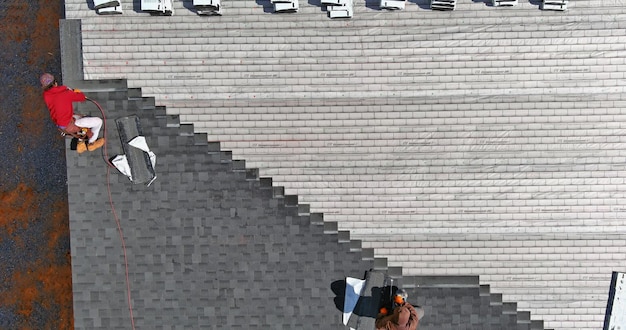 Luftaufnahme des Daches, das Asphaltschindeln mit neuen Schindeln eines Gebäudes installiert