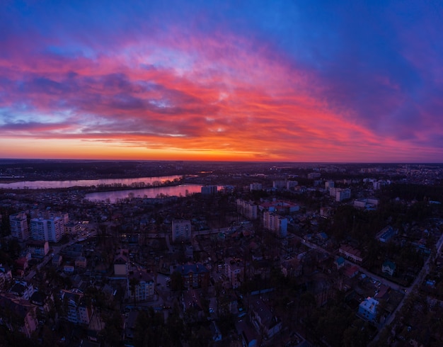 Luftaufnahme des dramatischen Sonnenuntergangshimmels über der Stadt in der Abenddämmerung.