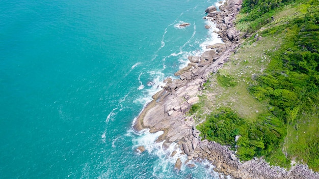 Luftaufnahme des Enseada-Strandes in Guaruj, Brasilien. Felsen und blaues Meer an der Küste.