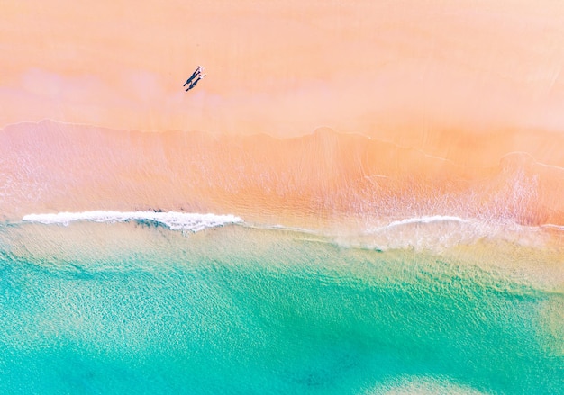 Luftaufnahme des fantastischen Strandes mit Flitterwochenpaaren, die im Morgenlicht in der Nähe des türkisfarbenen Meeres am Strand spazieren gehenDraufsicht auf die SommerstrandlandschaftUrlaubsreise- und Tourkonzept