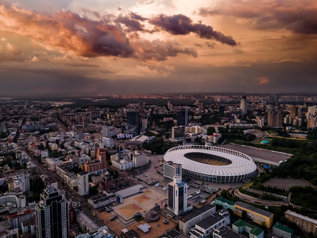 Luftaufnahme des Fußballstadions in der Stadt vor dem Hintergrund des Sonnenuntergangs und der schönen Wolken