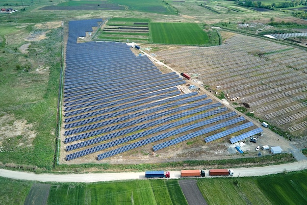 Luftaufnahme des im Bau befindlichen Elektrizitätswerks mit LKW, der Montageteile für Sonnenkollektoren auf Metallrahmen zur Erzeugung elektrischer Energie liefert Entwicklung von erneuerbarer Elektrizität