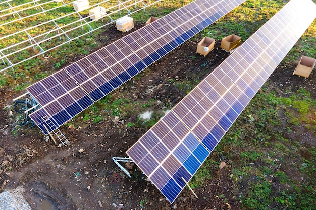 Luftaufnahme des im Bau befindlichen Solarkraftwerks auf der grünen Wiese. Montage von Elektropaneelen zur Erzeugung sauberer ökologischer Energie.