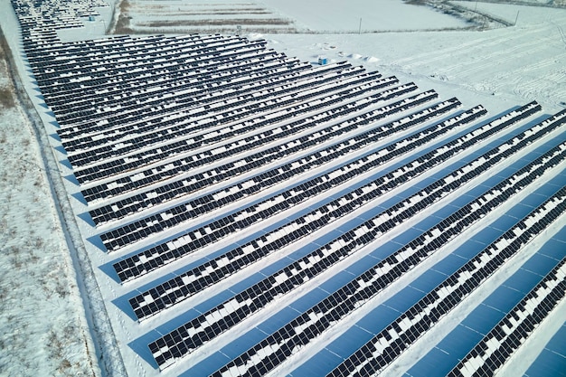 Luftaufnahme des Kraftwerks mit Sonnenkollektoren, die mit Schnee bedeckt sind, der im Winter schmilzt, um saubere Energie zu erzeugen Konzept der geringen Effektivität von erneuerbarem Strom in der nördlichen Region