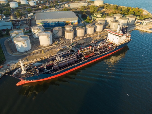 Luftaufnahme des Lagertanks der chemischen Industrie und des Tankschiffs, das in das Ölterminal einfährt