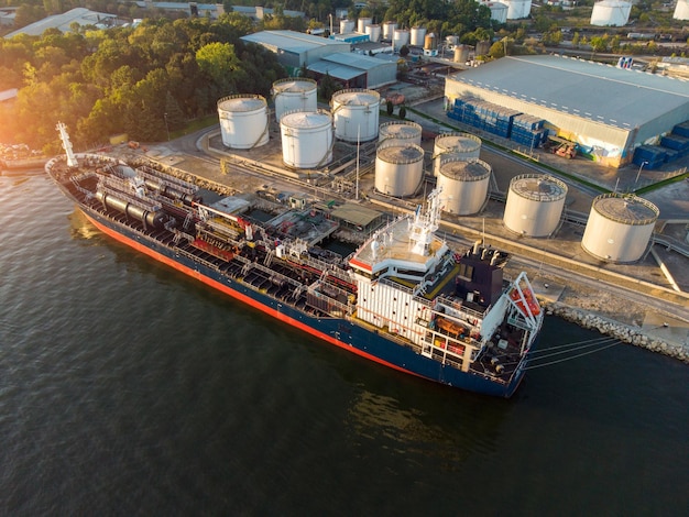 Luftaufnahme des Lagertanks der chemischen Industrie und des Tankschiffs, das in das Ölterminal einfährt