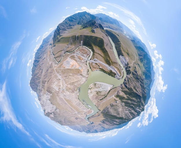 Foto luftaufnahme des planeten erde mit dem bild der natur und malerischen landschaften in der nähe eines berges mit einem fluss und grünen bäumen an einem sommertag und blauem himmel. ein kleiner und wehrloser planet