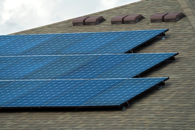 Luftaufnahme des regulären amerikanischen Hausdachs mit blauen Photovoltaik-Solarmodulen zur Erzeugung sauberer ökologischer elektrischer Energie Investition in erneuerbaren Strom für Alterseinkommen