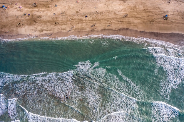 Luftaufnahme des Sandstrandes mit den Touristen, die im schönen klaren Meerwasser schwimmen