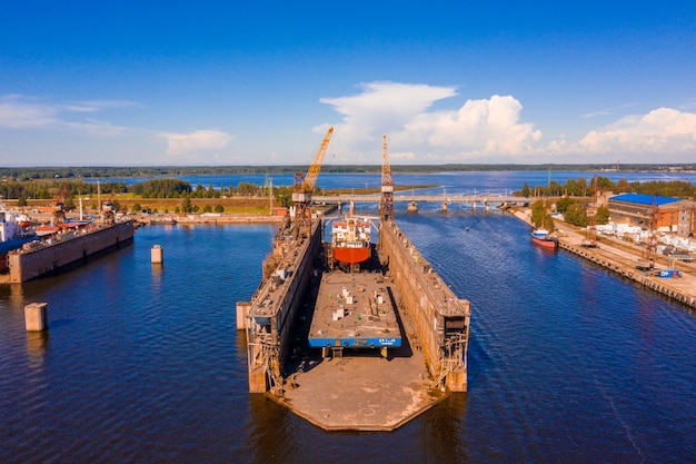 Luftaufnahme des Schiffes im schwimmenden Trockendock in Reparatur durch Sandstrahlen in Riga, Lettland.